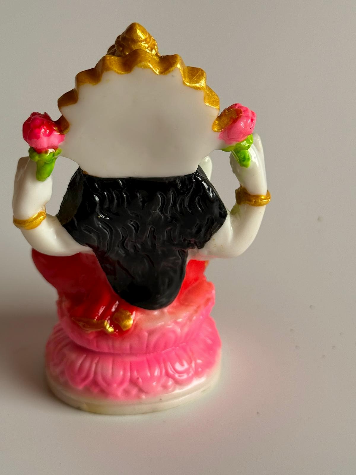 Side view showing the posture and floral details on the statue