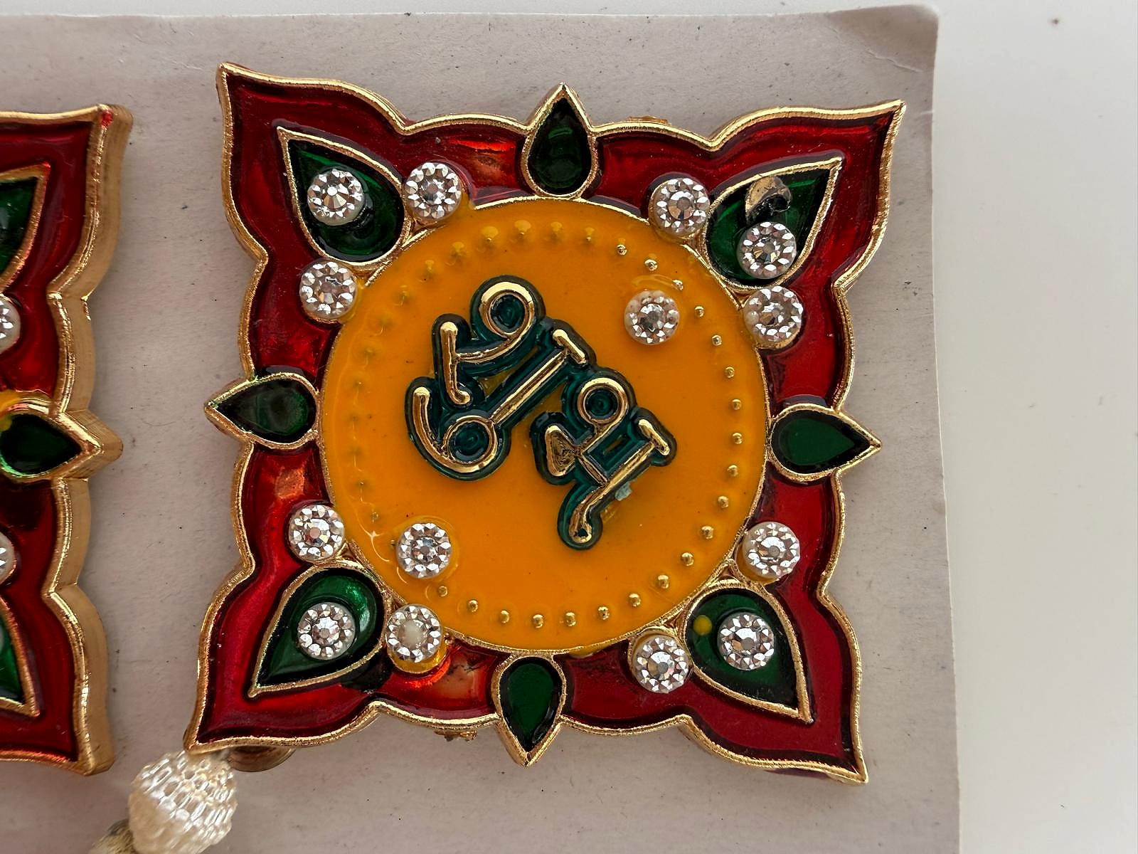 Close-up of Shubh Labh decorative wall hanging with vibrant gemstone accents