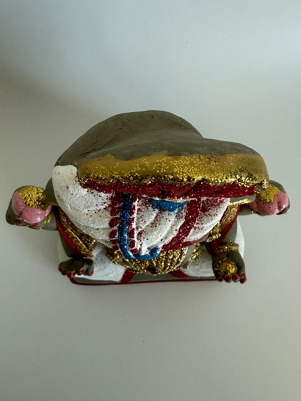 Top view of Ganesh idol with colorful attire and embellishments