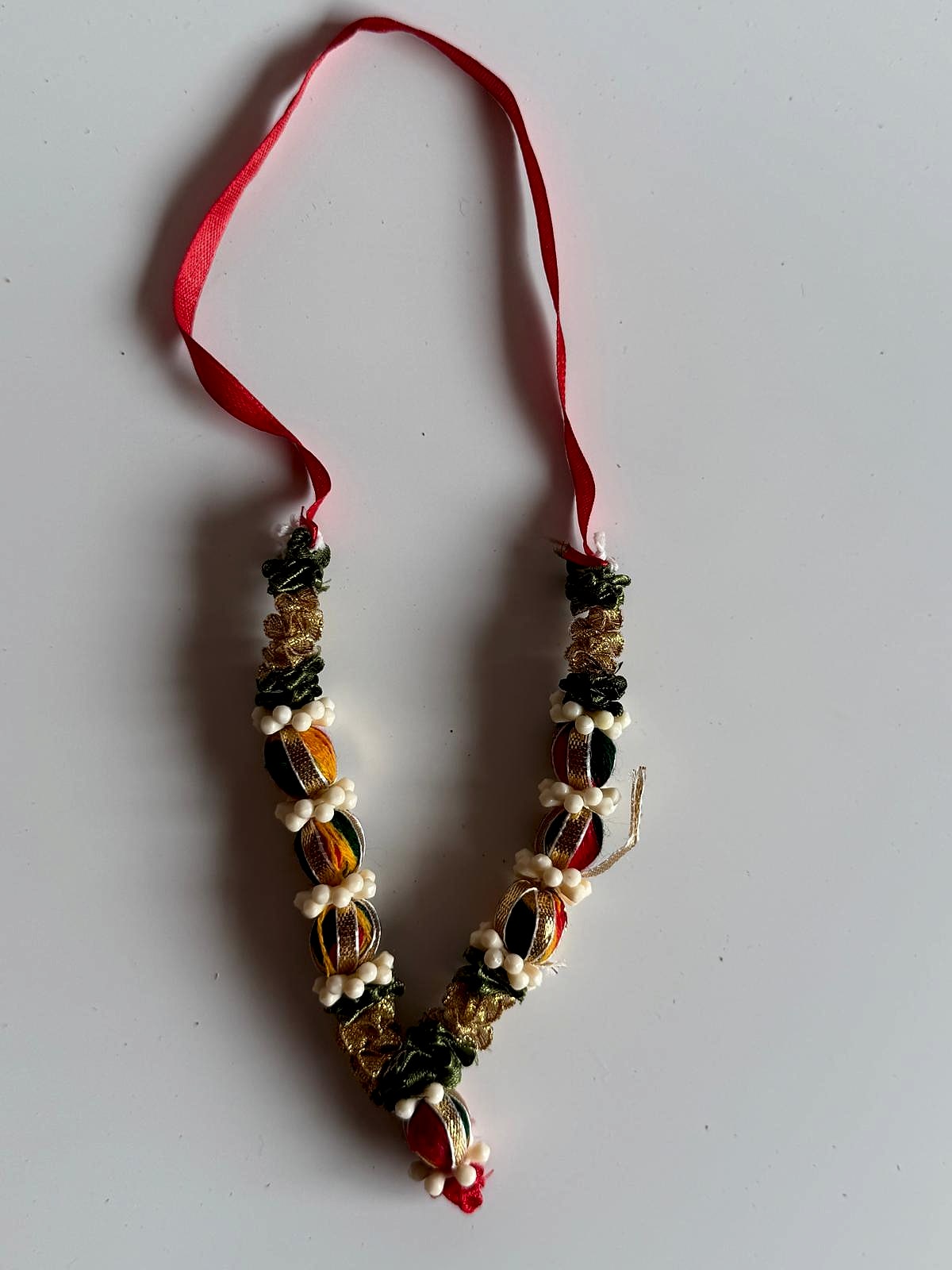 Handcrafted garland with red ribbon handle